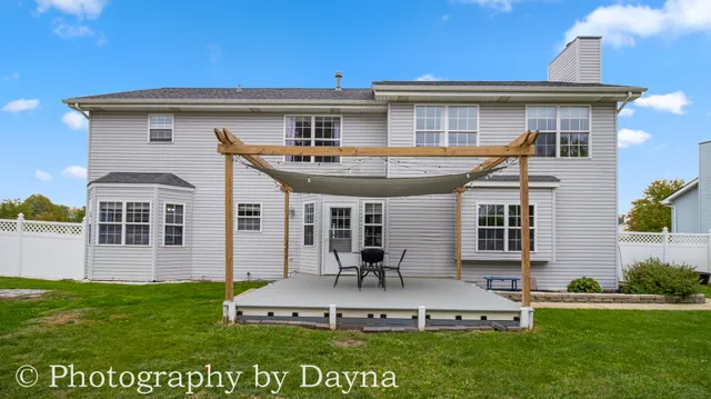 a view of a white house with a big yard and potted plants