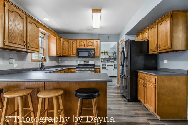 a kitchen with stainless steel appliances granite countertop a stove a refrigerator and a microwave