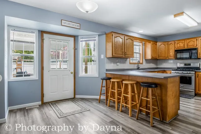 a kitchen with stainless steel appliances granite countertop a stove a sink and a granite counter tops with wooden cabinets