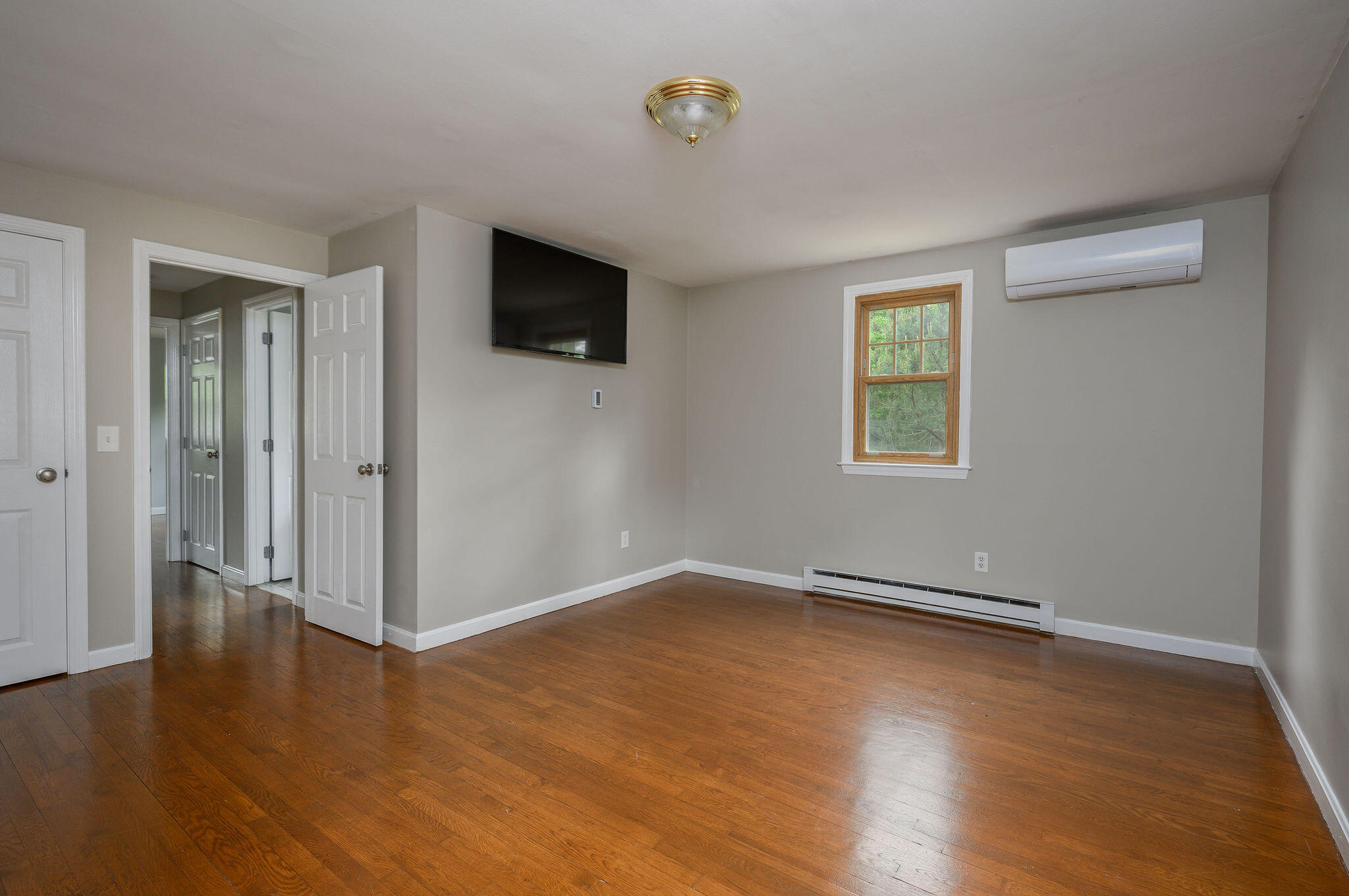 54 Beechwood Drive Mashpee, MA 02649 - Photo 27 of 34 an empty room with wooden floor and windows
