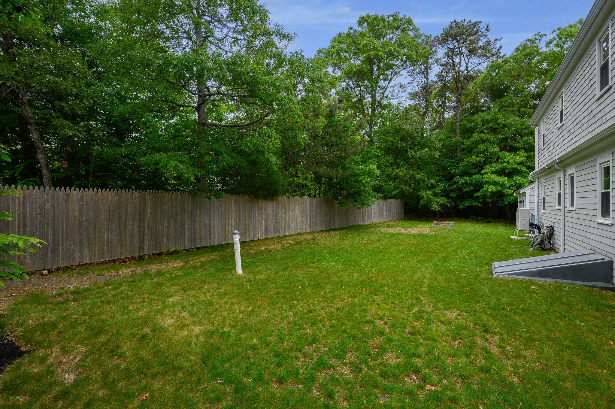 54 Beechwood Drive Mashpee, MA 02649 - Photo 34 of 34 a backyard of a house with plants and large tree