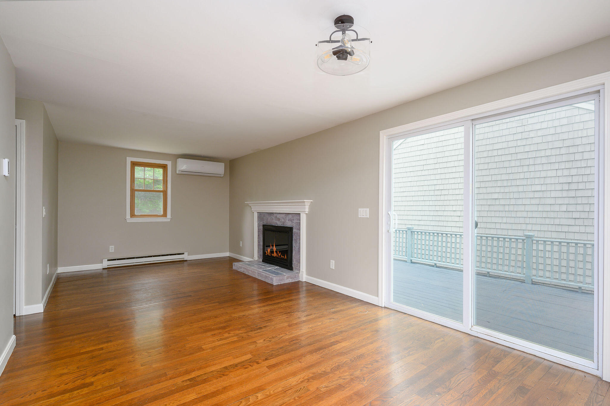 54 Beechwood Drive Mashpee, MA 02649 - Photo 9 of 34 an empty room with wooden floor and windows