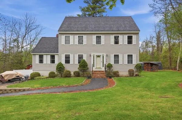 a front view of a house with a yard and trees