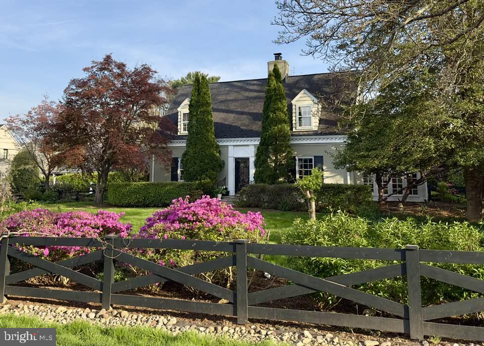 a front view of a house with a big yard and large trees