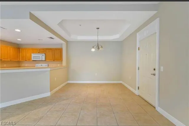 a view of a kitchen with a sink and dishwasher a refrigerator with white cabinets