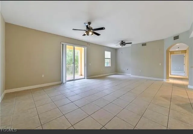 a view of a livingroom with a chandelier fan and windows