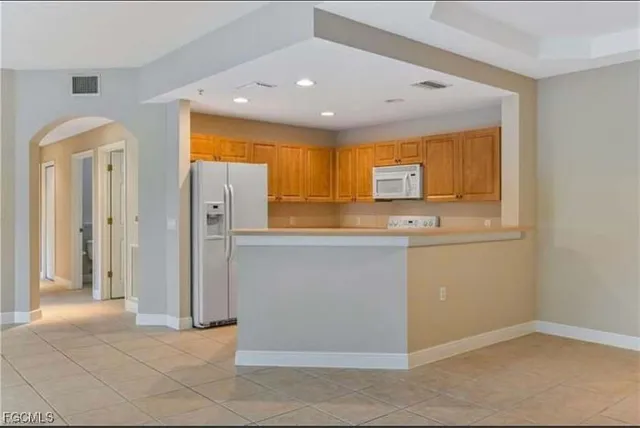 a view of kitchen with stainless steel appliances granite countertop a refrigerator and a sink