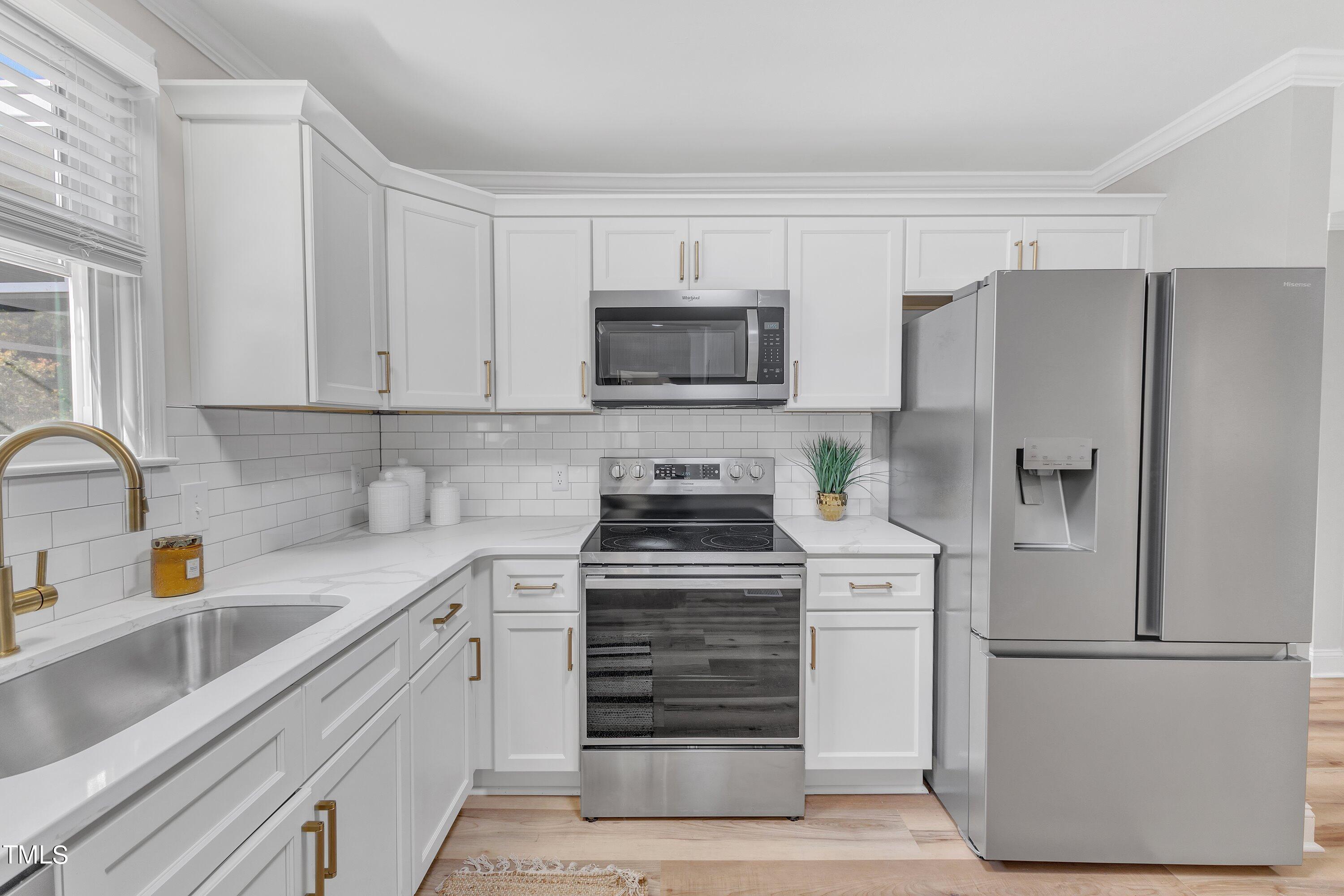 3440 Apache Drive Raleigh, NC 27609 - Photo 7 of 47 a kitchen with a refrigerator stove and white cabinets