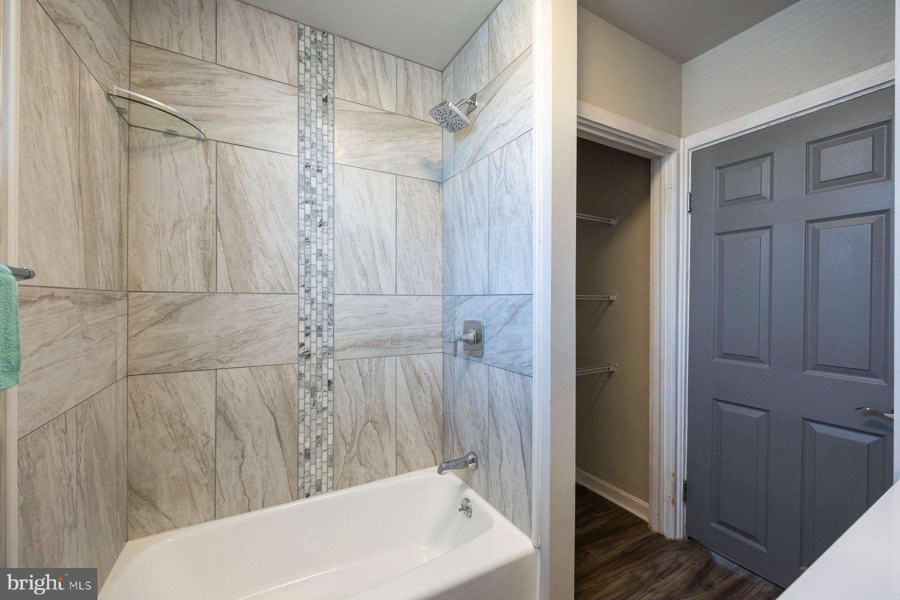 7508 Brightside Avenue Rosedale, MD 21237 - Photo 13 of 27 a bathroom with a white bath tub a shower and a toilet sink