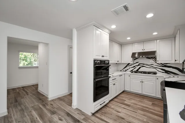 a kitchen with granite countertop a sink cabinets and stainless steel appliances