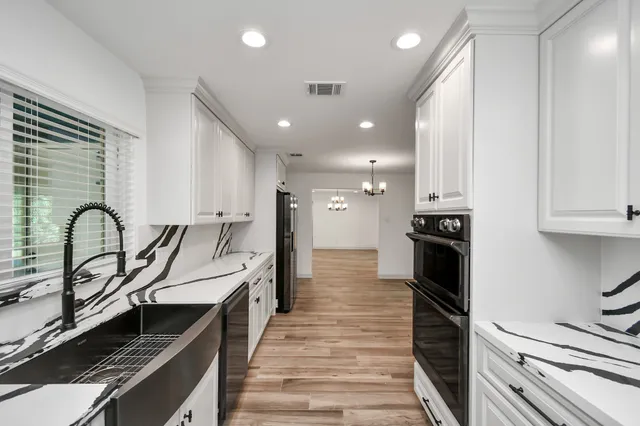 a open kitchen with stainless steel appliances granite countertop a stove and a sink