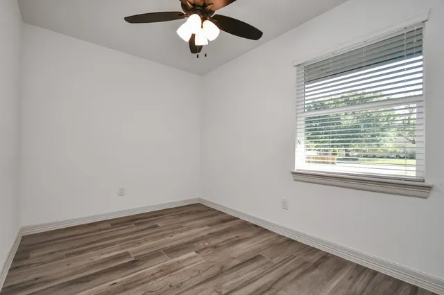 wooden floor in an empty room with a window