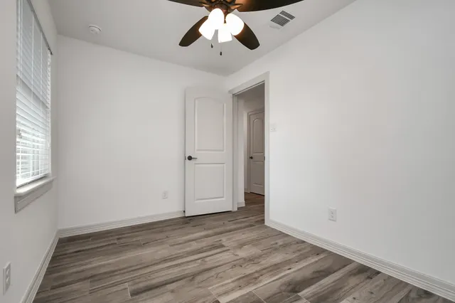 wooden floor in an empty room with a window