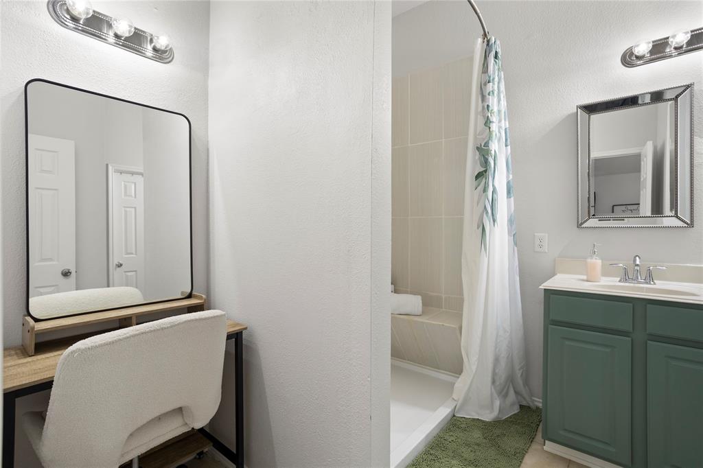 213 Arabian Road Waxahachie, TX 75165 - Photo 11 of 29 Bathroom with vanity, a stall shower, and a textured wall