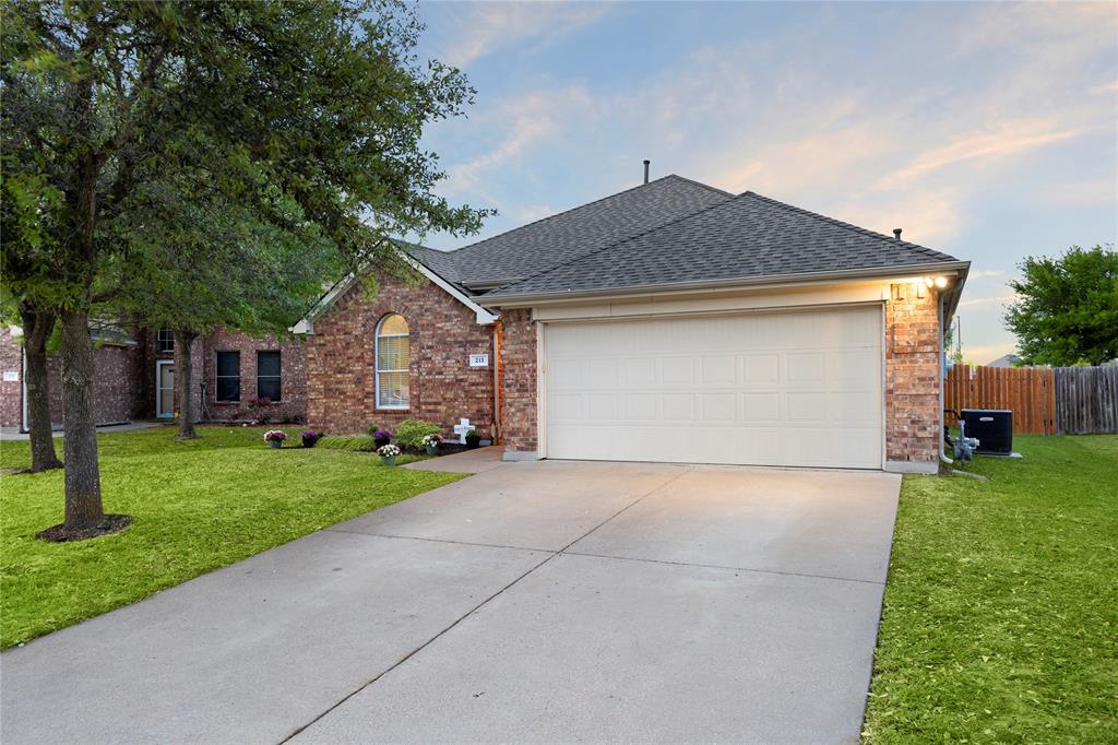 213 Arabian Road Waxahachie, TX 75165 - Photo 2 of 29 View of front facade featuring an attached garage, brick siding, driveway, and roof with shingles