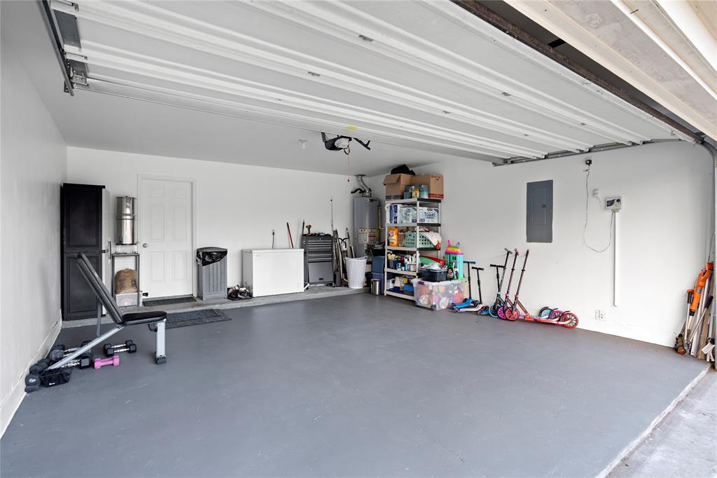 213 Arabian Road Waxahachie, TX 75165 - Photo 20 of 29 Garage with white fridge, electric panel, and water heater