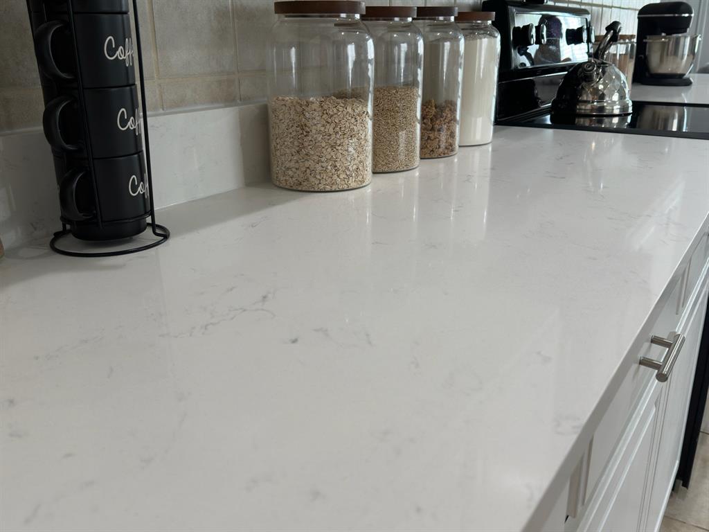 213 Arabian Road Waxahachie, TX 75165 - Photo 5 of 29 Detailed view of light stone countertops and range with electric cooktop