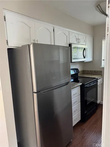 a white refrigerator freezer and a stove sitting inside of a kitchen