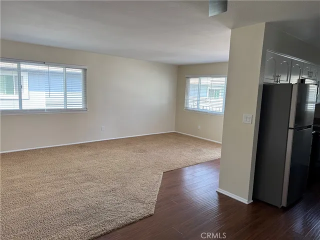 an empty room with wooden floor and a window