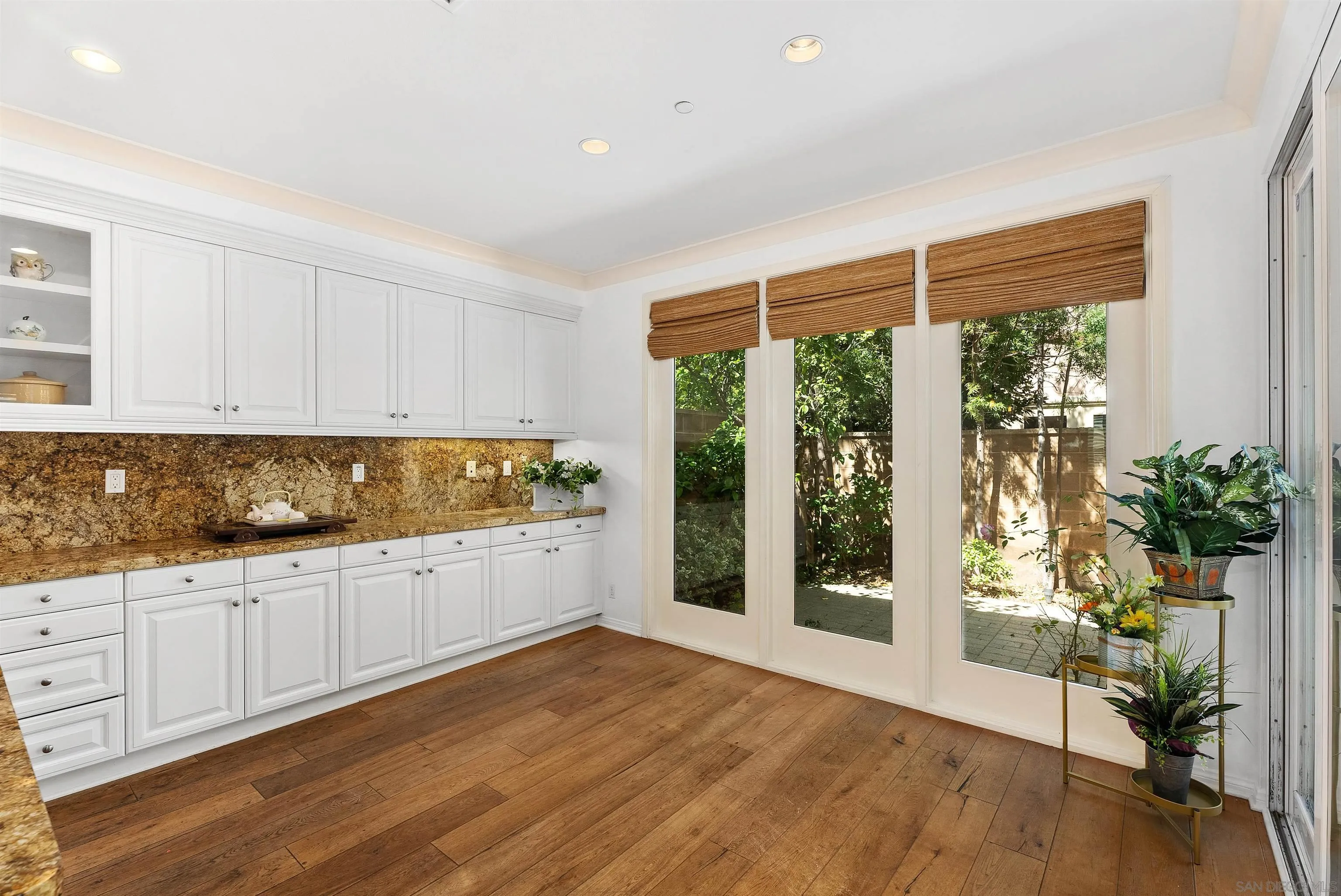 55 Diamond Irvine, CA 92620 - Photo 11 of 30 a large white kitchen with white cabinets and wooden floor