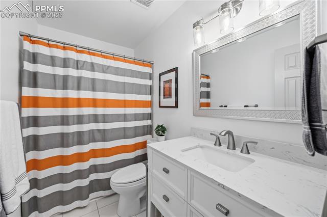 2135 Glenhill Road Colorado Springs, CO 80906 - Photo 7 of 50 Bathroom featuring a shower with curtain, vanity, and light tile patterned floors