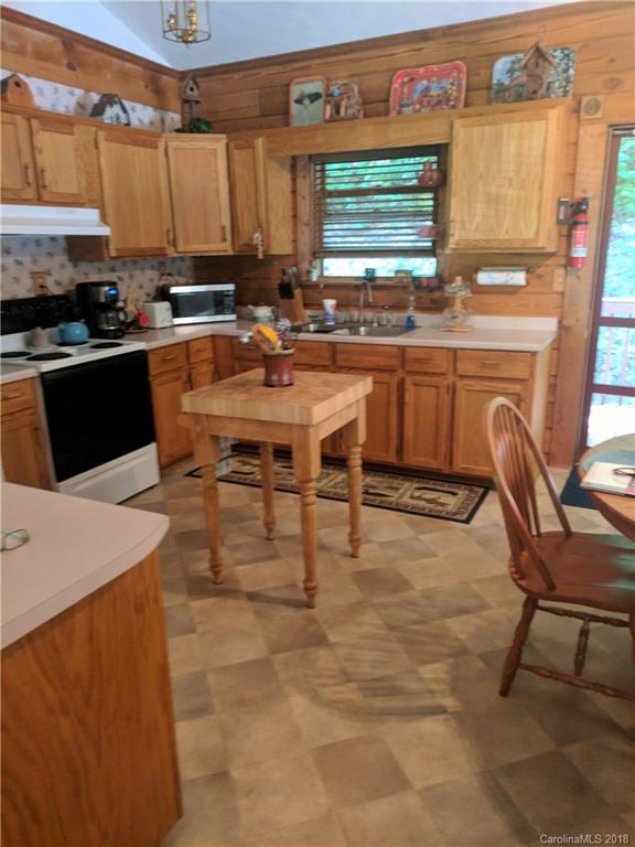 127 Dolan Lane, Unit 8338 Clyde, NC 28721 - Photo 5 of 21 a kitchen with a sink a stove and chairs