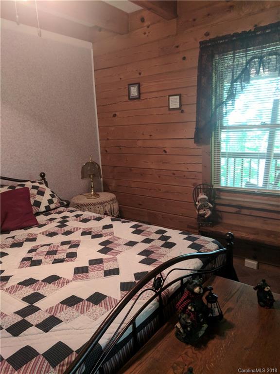 127 Dolan Lane, Unit 8338 Clyde, NC 28721 - Photo 10 of 21 a bed sitting in a bedroom next to a window