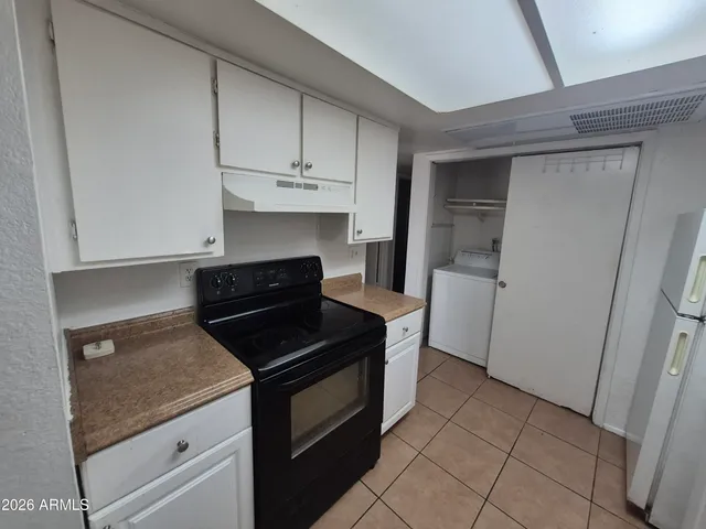 a kitchen with granite countertop white cabinets and black appliances