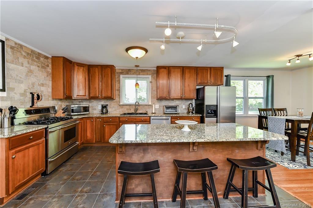 526 Scaleybark Road Charlotte, NC 28209 - Photo 10 of 37 a large kitchen with granite countertop a stove a sink a counter space and stainless steel appliances