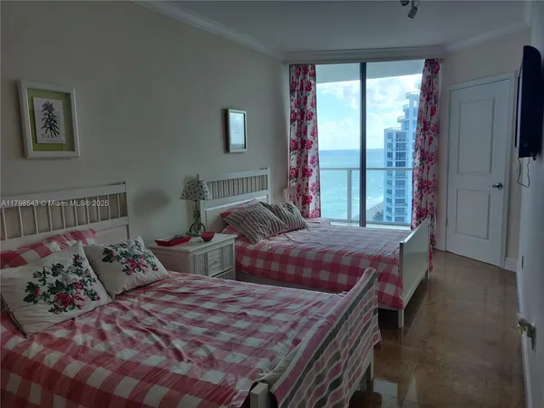 a bedroom with two beds and a large window