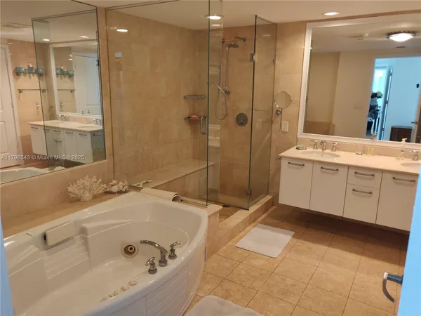 a bathroom with a tub sink and mirror