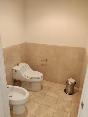 a white toilet sitting next to a bathroom sink