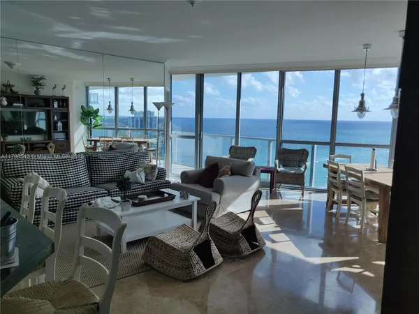 a living room with furniture and a floor to ceiling window