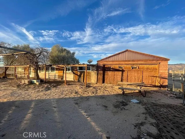 a dirt road with an house in the background