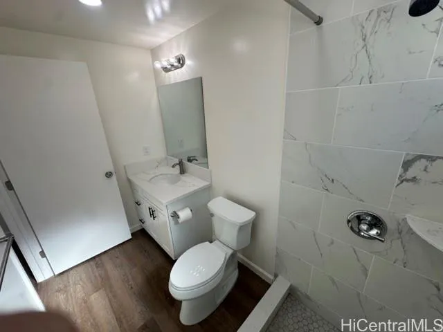 a white toilet sitting next to a bathroom sink and a mirror