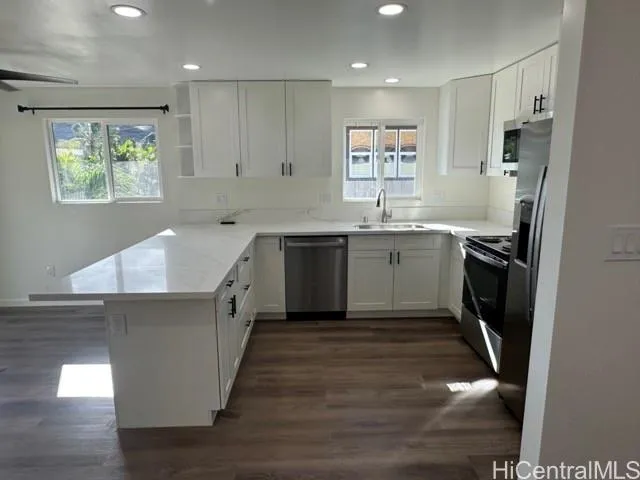a large kitchen with stainless steel appliances granite countertop a sink stove and refrigerator