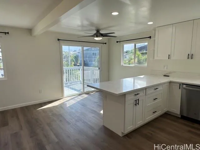 a kitchen with stainless steel appliances granite countertop a refrigerator a sink dishwasher a stove and white countertops with wooden floor