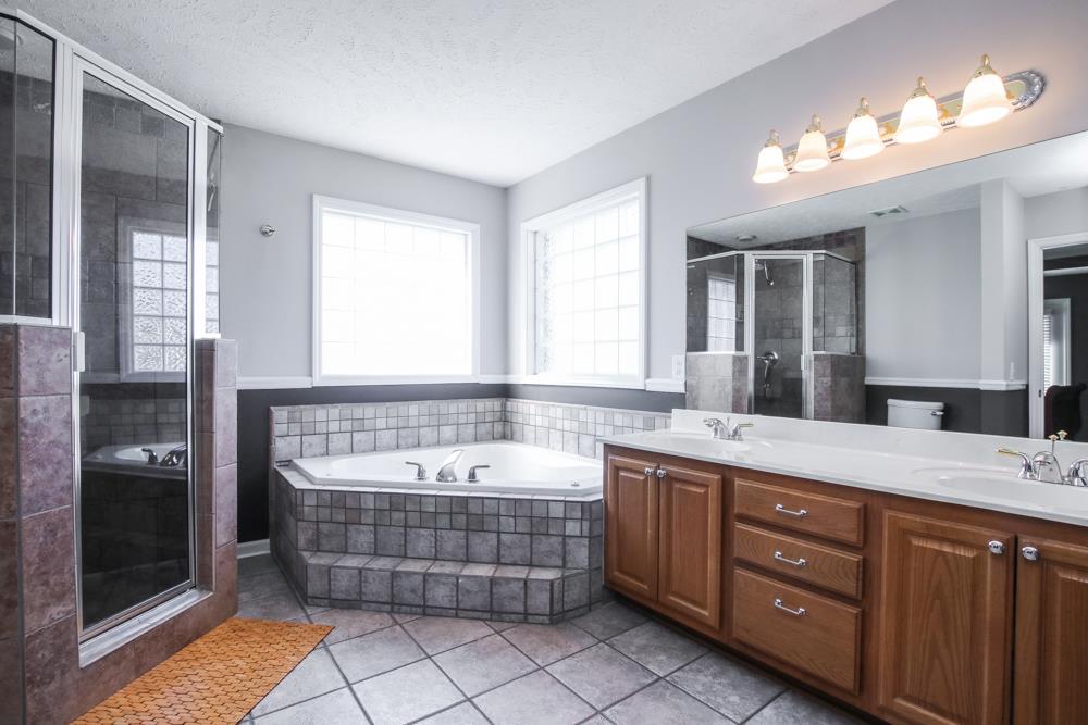 4079 Yeargan Road Murfreesboro, TN 37128 - Photo 17 of 30 a spacious bathroom with a tub double vanity sink and mirrors