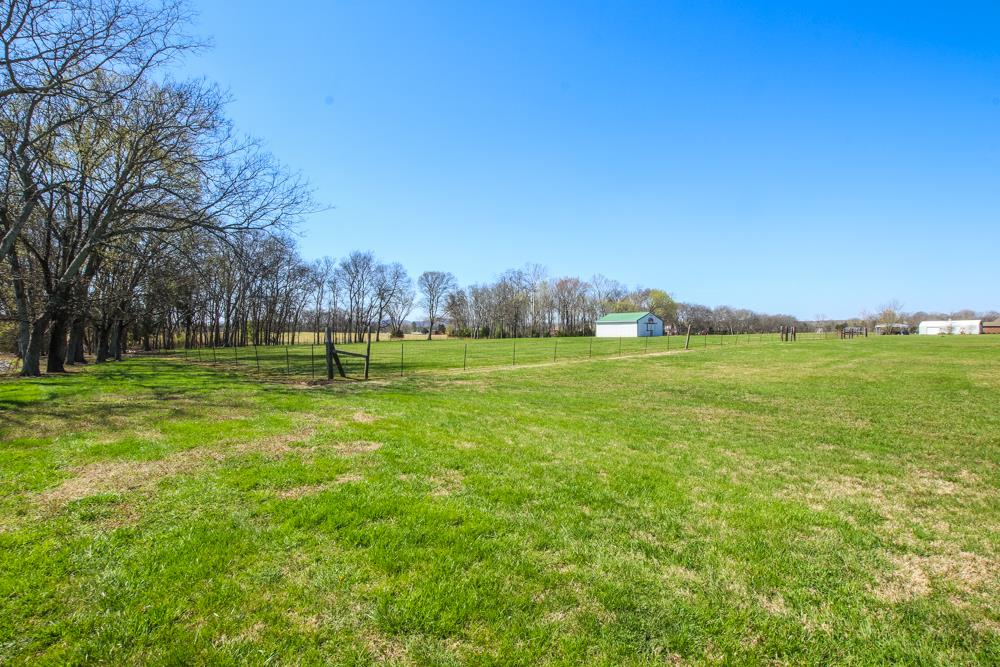 4079 Yeargan Road Murfreesboro, TN 37128 - Photo 25 of 30 a backyard of a house with lots of green space and fog
