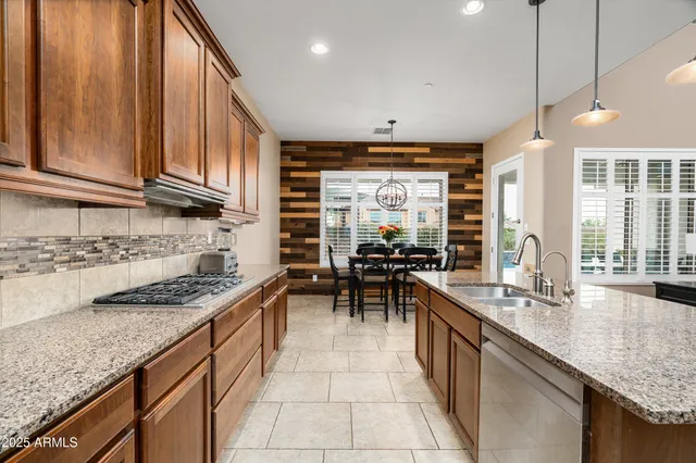 a kitchen with stainless steel appliances granite countertop wooden cabinets a stove a sink and a refrigerator