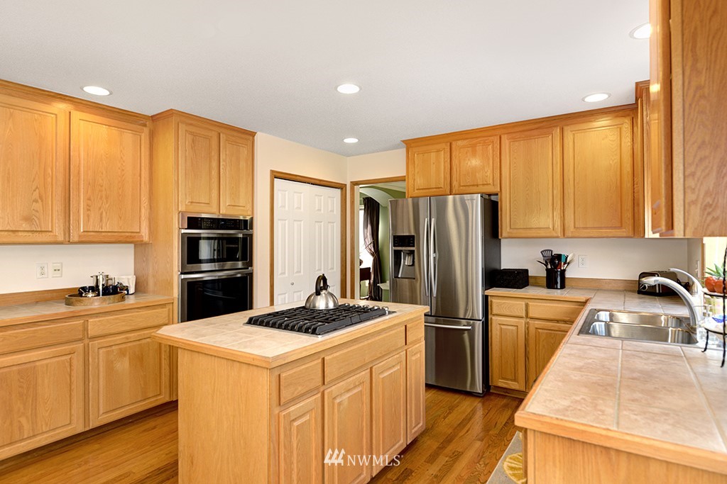 19014 33rd Avenue Southeast Bothell, WA 98012 - Photo 9 of 23 a kitchen with a sink a stove a refrigerator and cabinets