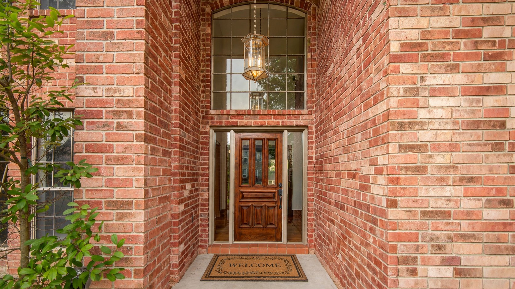 8412 Hidden Trail Lane Spring, TX 77379 - Photo 4 of 38 The covered front entry features classic brick architecture, a grand two-story window, and a warm wood front door that creates an elegant first impression.