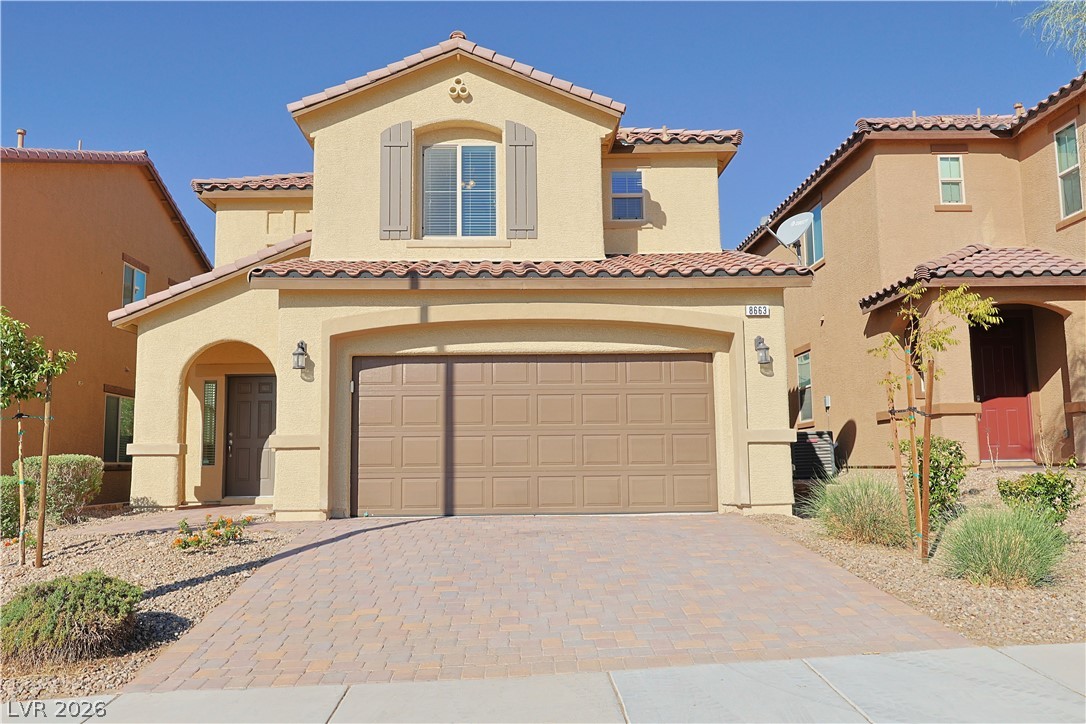 8663 Reynolds Spring Street Las Vegas, NV 89178 - Photo 1 of 32 A paved driveway leads to the spacious two-car garage of this multi-level stucco home.