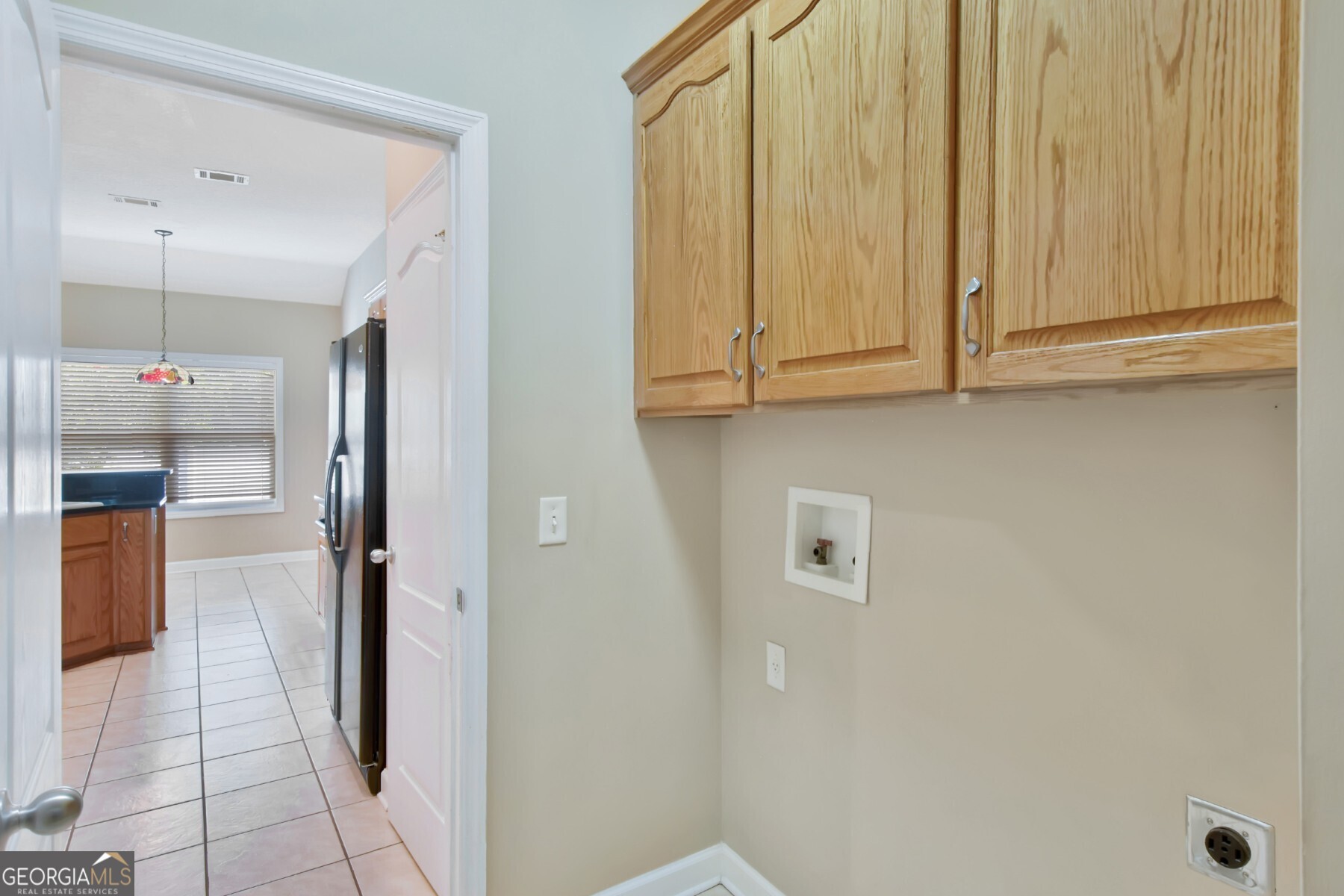 138 Arlington Way Brunswick, GA 31523 - Photo 13 of 32 a view of a refrigerator in kitchen and an empty room with wooden floor