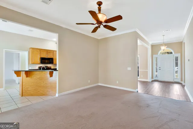 a view of a livingroom with a ceiling fan and window