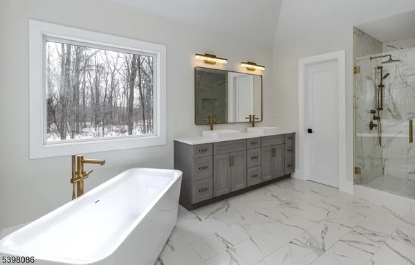 a spacious bathroom with a double vanity sink a large mirror a bathtub and window