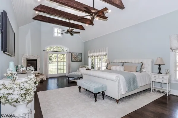 a spacious bedroom with a bed a couch and large windows