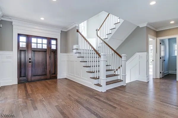 a view of entryway with wooden floor and stairs