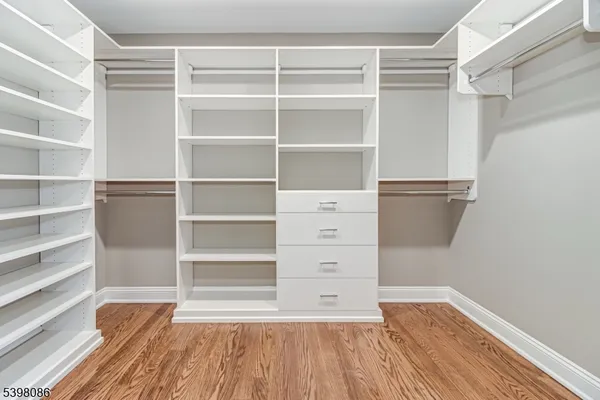 a room with walk in closet and wooden floor
