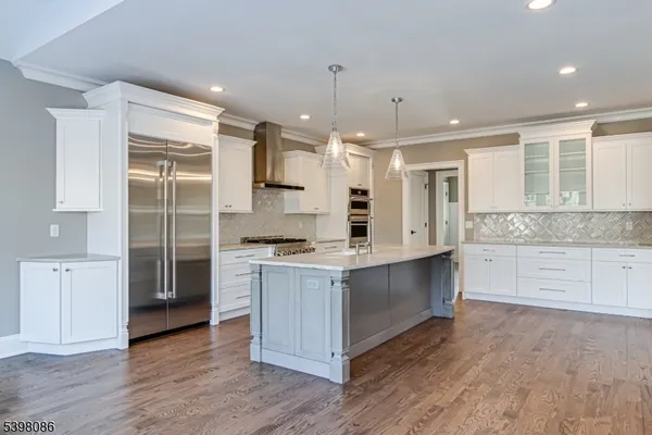 a large kitchen with cabinets wooden floor and stainless steel appliances